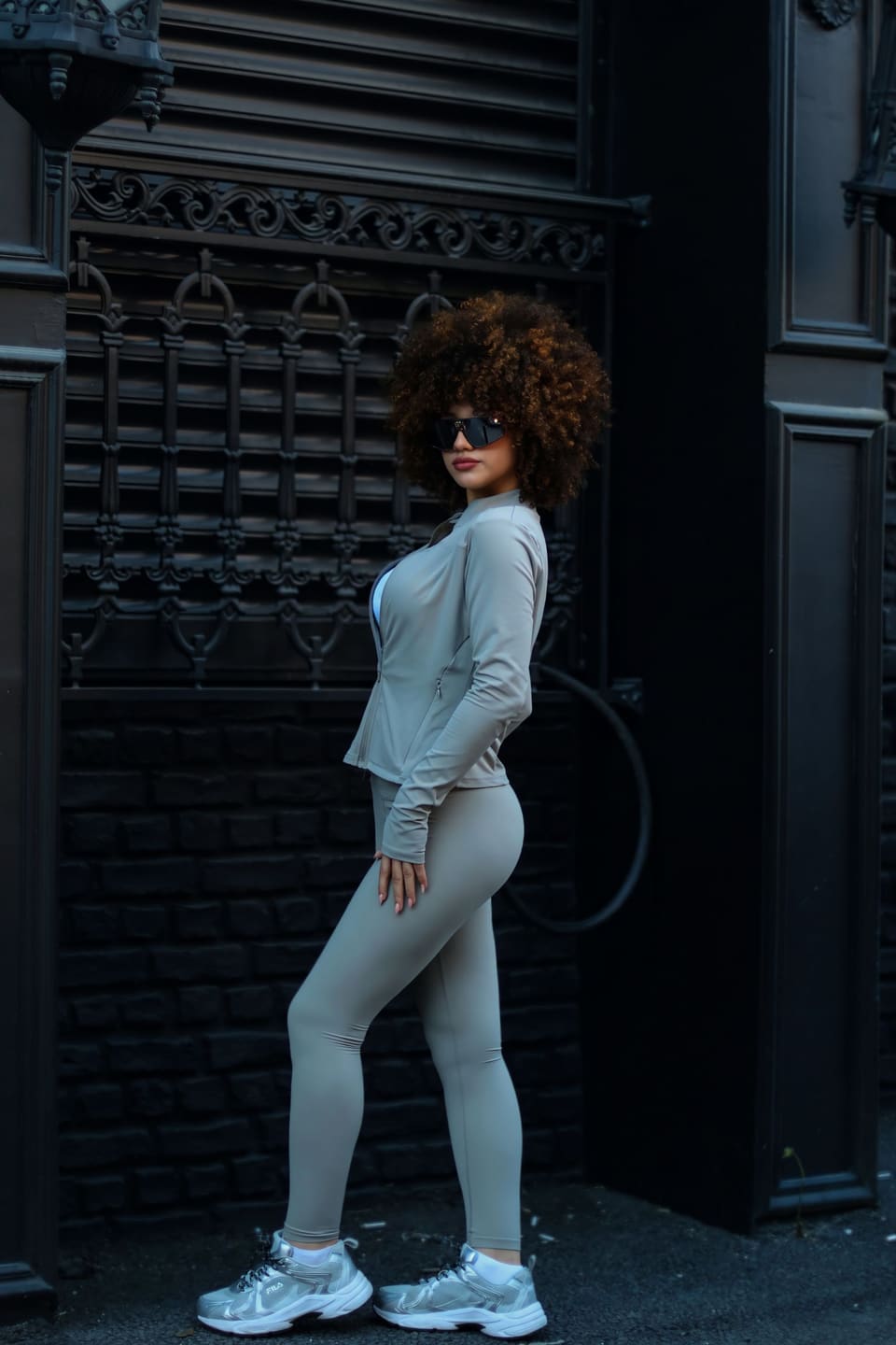 Off-duty athleisure: Woman striking a fashion pose on urban street, showcasing modern activewear.